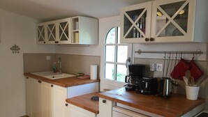 A kitchen with white cabinets, a wooden countertop, a coffee maker, a toaster, and a dishwasher. - Set of houses, with heated indoor pool, surrounded by nature (Le Tablier)