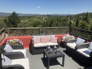A patio with wicker furniture, a small table, and flower arrangements. - OLD BUILDING Pool, Garden and Terrace views towards GORDES and JOUCAS (Goult)