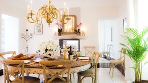 A dining area with a round table, chairs, a chandelier, and a potted plant. - OLD BUILDING Pool, Garden and Terrace views towards GORDES and JOUCAS (Goult)