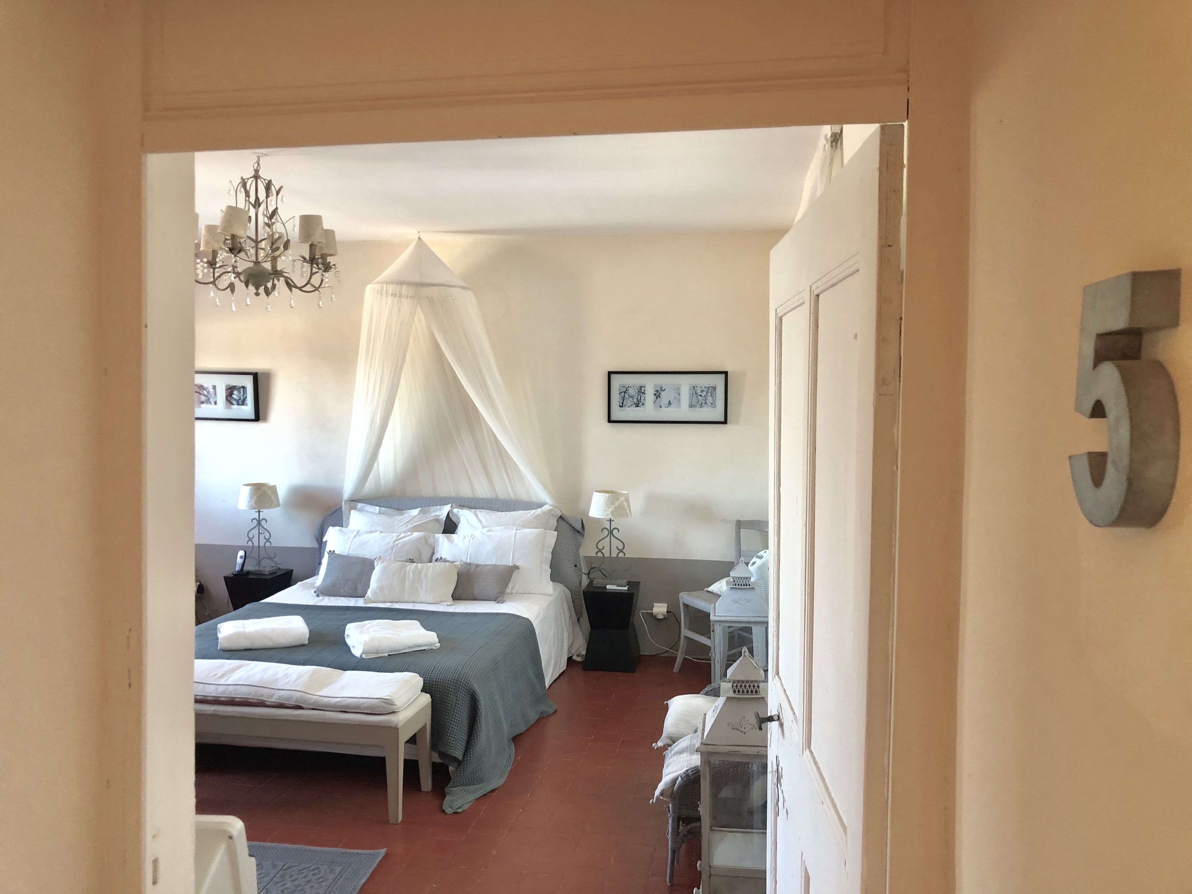 Ein Schlafzimmer mit Baldachinbett, Nachttischen, Schreibtisch und Stuhl.