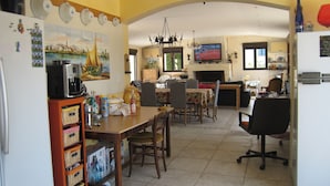 A kitchen with a dining area, a TV, and a fireplace. - House near the SEA - private SWIMMING POOL - COUNTRYSIDE - in LANGUEDOC - 15 people (Loupian)