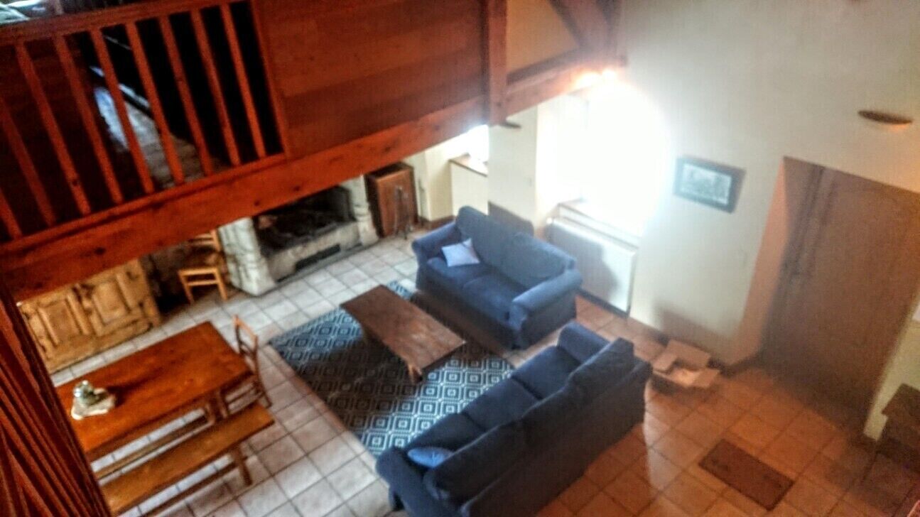 A living room with a fireplace, a sofa, a coffee table, and a patterned rug.