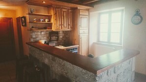 Une cuisine avec des meubles de rangement en bois, un plan de travail, une cuisinière et une fenêtre.