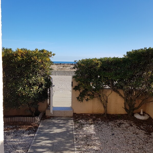 Un sendero que lleva a una playa con vista despejada al mar.