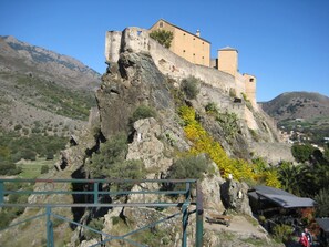 Un castillo enclavado en un acantilado rocoso con vistas despejadas del paisaje circundante.