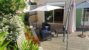 A wooden deck with wicker furniture and a white umbrella. - Villa, near Ile Rousse and the sea, lake and mountain view (Santa-Reparata-Di-Balagna)