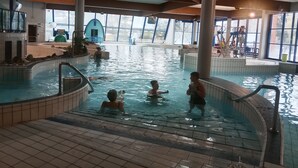 An indoor swimming pool with tiled walls and a high ceiling. - Apartment, garden level, with mountain views, close to the center.  (Briançon)