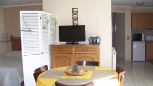 A compact living space with a dining area, a television, and a kitchenette. - Apartment, garden level, with mountain views, close to the center.  (Briançon)