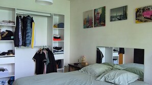 Ein Schlafzimmer mit Bett, Kleiderschrank und Spiegel.