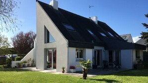 A modern two-story house with a sloped roof, large windows, and a well-maintained lawn. - Detached family home south brittany less than 200 m from the beach  (Larmor-Plage)