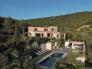 A modern house with a pool, surrounded by lush greenery and hills. - Facing the sea, air-conditioned villa for 10 people, with spa and secure heated pool (Conca)