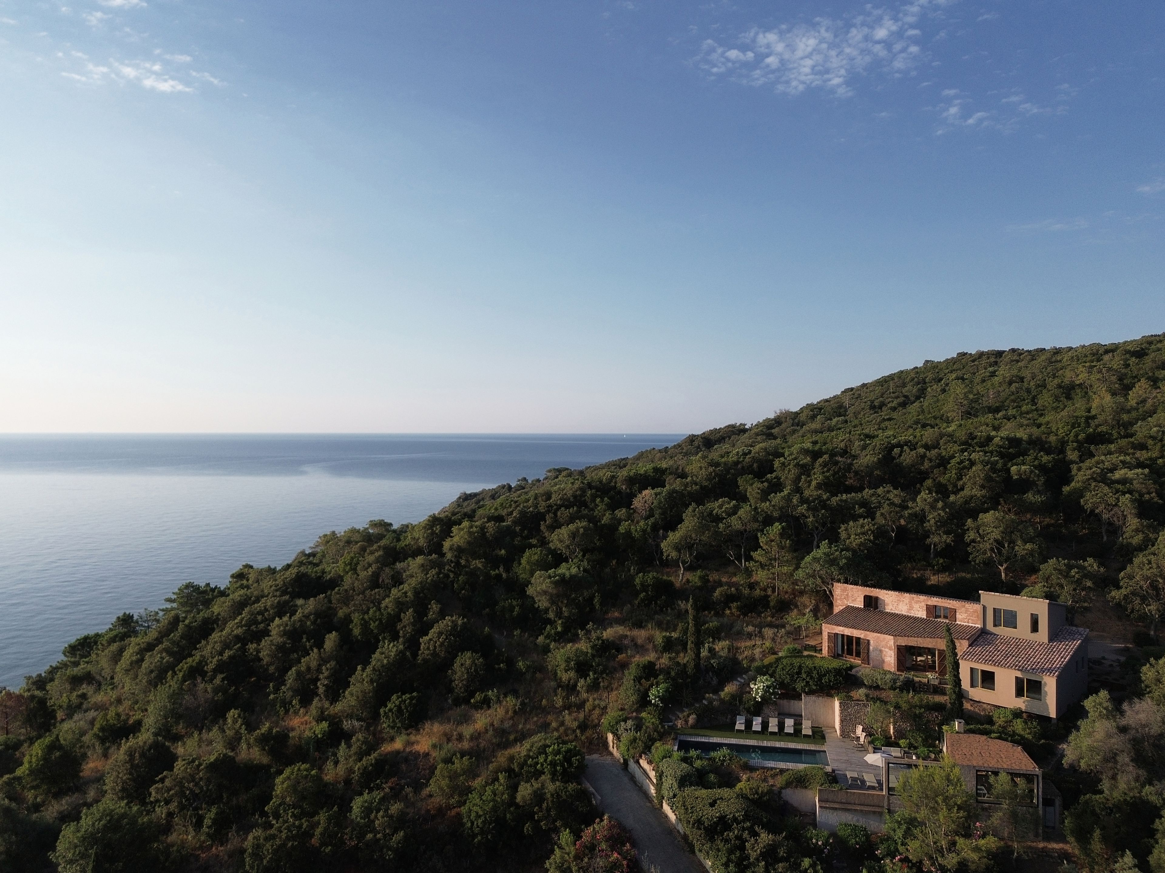 Une villa située sur une colline, avec piscine et vue sur la mer.