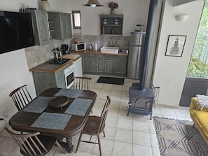 Une cuisine moderne avec un coin repas, comprenant une cuisinière, un four à micro-ondes et un réfrigérateur.