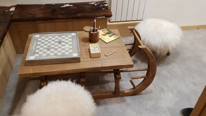 Une table en bois avec un jeu d’échecs, une petite boîte en bois et un livre.