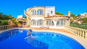 A large, two-story building with a swimming pool in front.