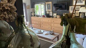 A living room with a wooden cabinet, a television, and framed pictures on the wall. - Villa 6 people swimming pool port vecchio (Porto vecchio)