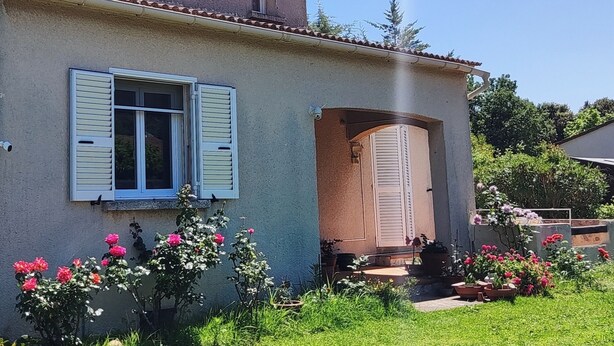 A two-story house with a balcony and a garden with pink flowers. - Small cozy nest for peaceful vacations (Lucciana)
