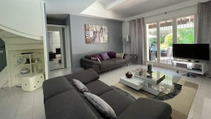 A modern living room with a sofa, coffee table, and a TV.