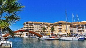 A marina with boats, a bridge, and a hotel with multiple balconies.