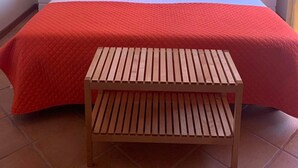 A hotel room with a large bed, two nightstands, a wooden bench, a sunset painting, and a butterfly decoration. - House Aveiro heated pool (Gafanha do Carmo)