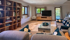 A living room with a sofa set, a coffee table, a TV, and a bookshelf.