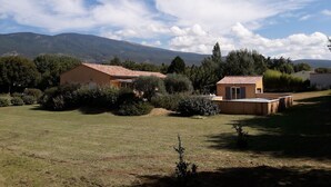 A rural property with a large house and a smaller building, surrounded by trees and a grassy field, with mountains in the background. - Bedoin new villa (100m town center) Mont Ventoux, private pool  (Bédoin)