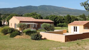 A building with a tiled roof, surrounded by greenery and mountains in the background. - Bedoin new villa (100m town center) Mont Ventoux, private pool  (Bédoin)