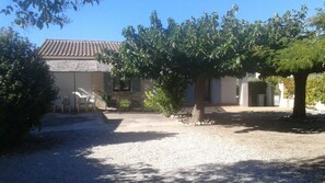 A house with a tiled roof, a gravel driveway, and a tree in the foreground. - Vacation villa in quiet neighborhood near town center (Pernes-Les-Fontaines)