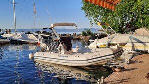 Un puerto deportivo con varias embarcaciones amarradas, incluyendo un bote inflable blanco con el nombre 'medline' y la matrícula 'CM 891011 A'.