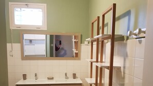 A bathroom with a double sink, wooden vanity, and a mirror. - Spacious and pleasant house (Castelnau-De-Guers)