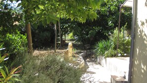 A garden pathway leading to a building with a bench and a yellow fire hydrant. - Spacious and pleasant house (Castelnau-De-Guers)