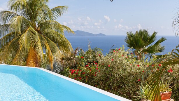 Ein Swimmingpool mit Blick auf das Meer und die Berge.