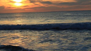 A sunset over the ocean with waves.