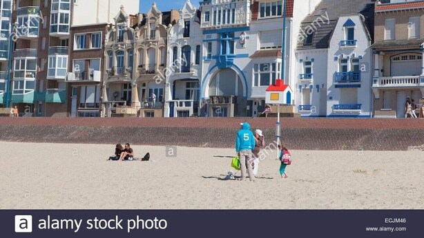 Una spiaggia con persone e edifici sullo sfondo.