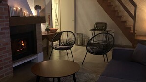 Un accogliente soggiorno con camino, una scala e un divano.