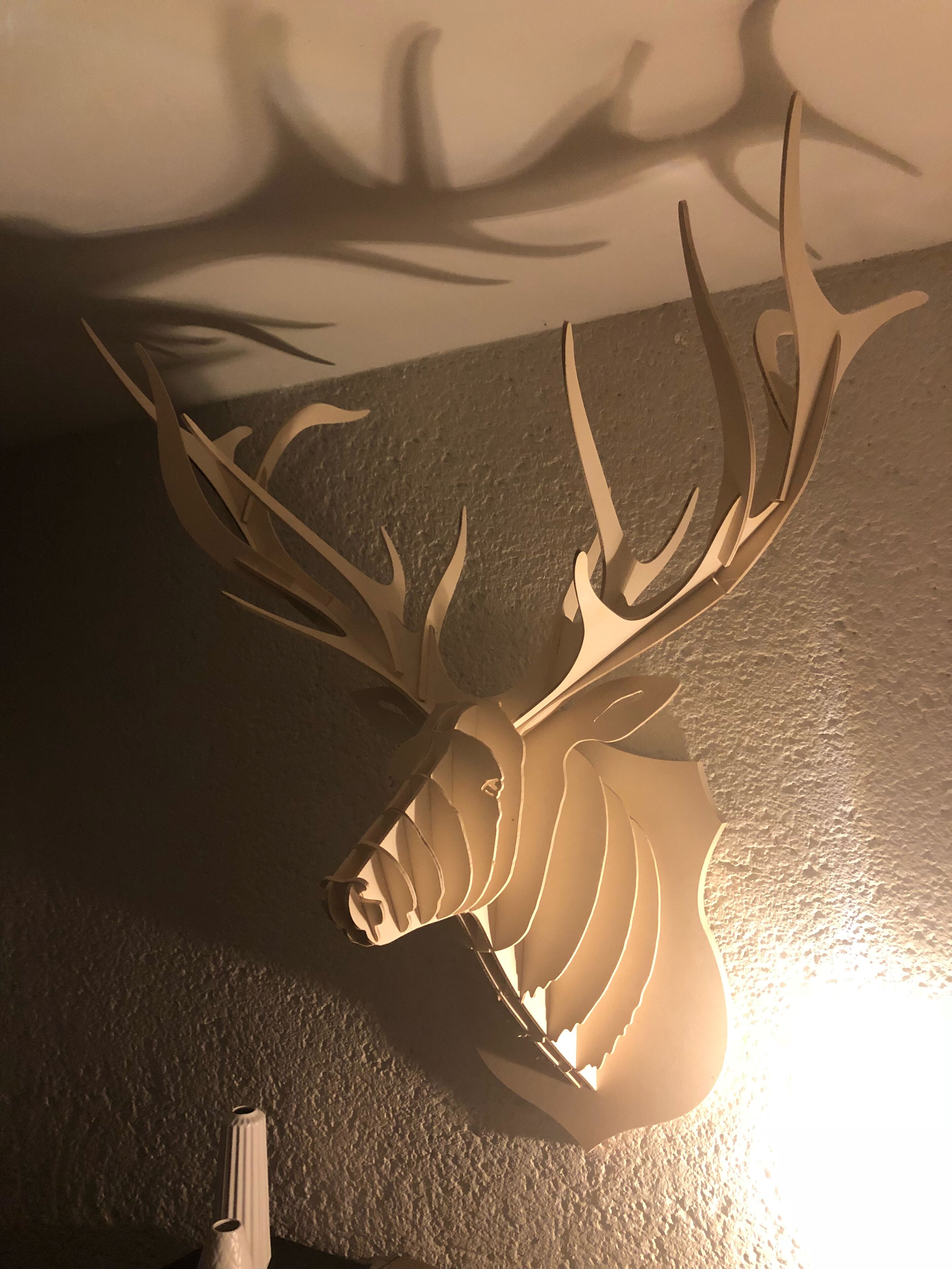 Una scultura di cervo a testa di pelo montato su una parete strutturata.