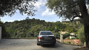 Ein Auto auf einer Auffahrt mit einem gepflasterten Weg, der zu einem verschlossenen Eingang führt.