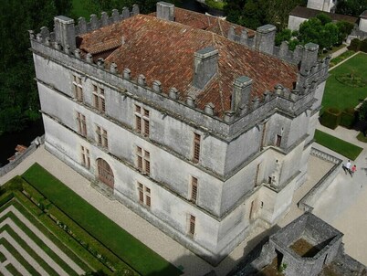 Chalet overlooking a pond in a green setting.