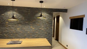 A modern dining area with a wooden table and two pendant lights. - CHARMING APARTMENT 4 ROOMS 9 PEOPLE AVORIAZ (Morzine)