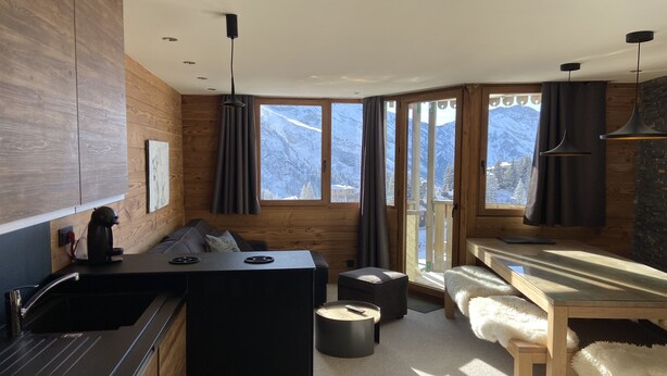 A modern kitchen with a central island, wooden cabinetry, and a view of snow-capped mountains. - CHARMING APARTMENT 4 ROOMS 9 PEOPLE AVORIAZ (Morzine)