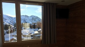 A room with a large window offering a view of snow-covered buildings and mountains. - CHARMING APARTMENT 4 ROOMS 9 PEOPLE AVORIAZ (Morzine)