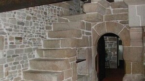 Uma escadaria de pedra que leva a uma porta em arco.