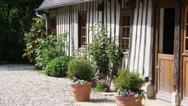 Un bâtiment traditionnel doté d’un toit en pente et d’une allée gravillonnée.