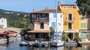 Una propiedad frente al agua con restaurante, barcos amarrados y edificios con balcones.