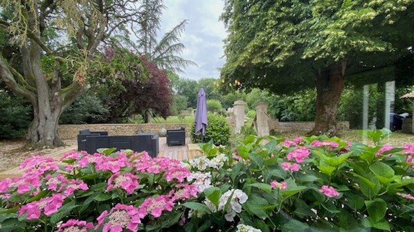 A garden with flowering plants and a stone bench.