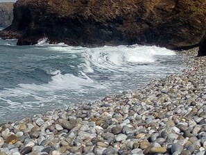 A rocky beach with waves crashing onto the shore.