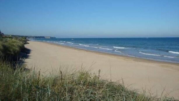 Een strand met een zandstrand en golven.