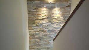 Una escalera con un muro de piedra a un lado y una barandilla de madera al otro.