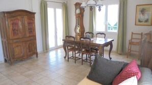 A dining area with a wooden table and chairs, a large wooden cabinet, and a chandelier. - House in Saint Victor la Coste in Provence, between Avignon and Pont du Gard (Saint-Victor-La-Coste)