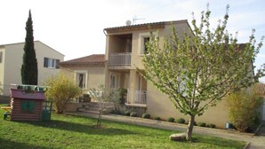 A two-story house with a balcony, a small garden, and a tree in front. - House in Saint Victor la Coste in Provence, between Avignon and Pont du Gard (Saint-Victor-La-Coste)